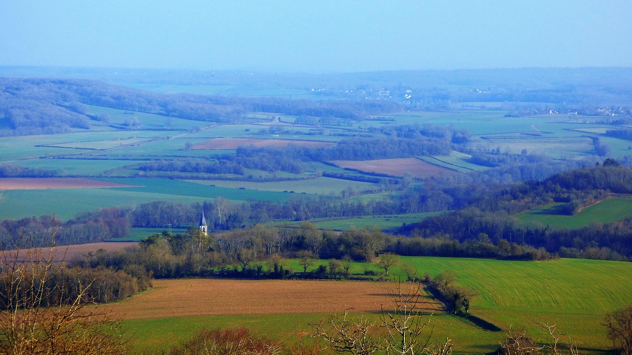 Blick über eine Kulturlandschaft aus Feldern, Hecken und Waldinseln